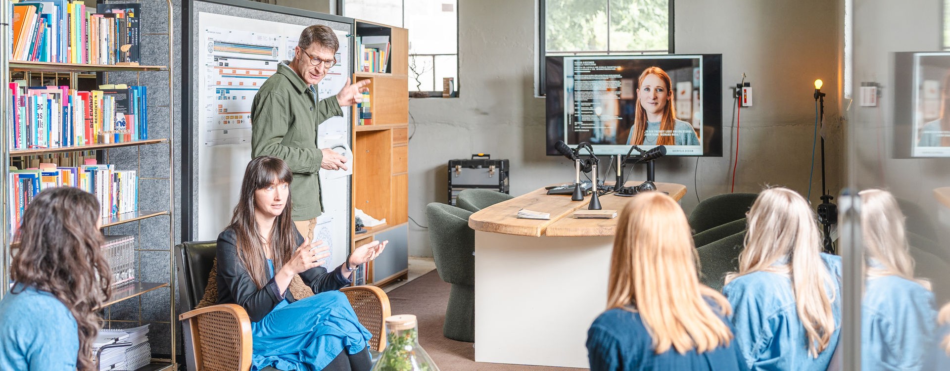 Team im Gespräch, sitzend vor einem Screen